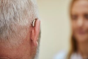 Female doctor and senior man with hearing aid